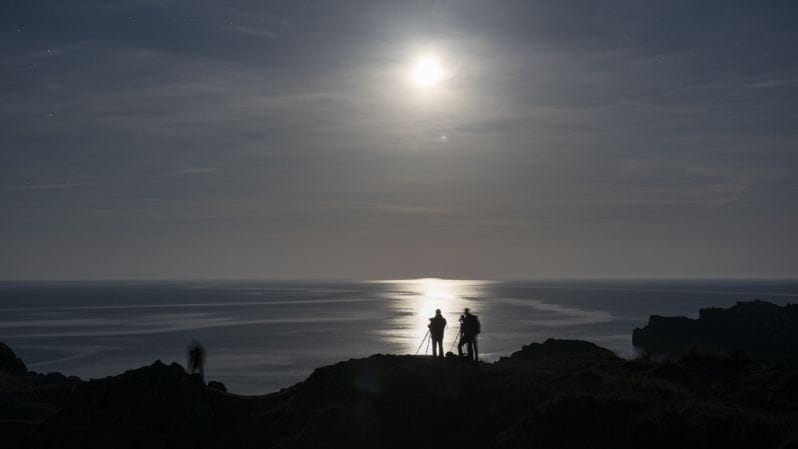 Photographers taking photos of a hill ciff at on Llanddwyn Island Anglesey with The Welshot Photographic Academy Evening Learning to shoot in Low-Light