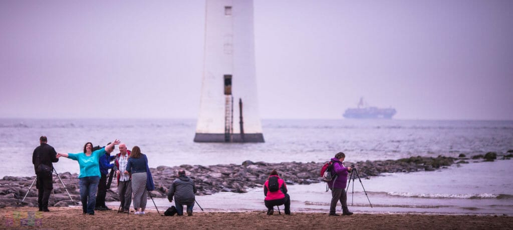How To Choose A Photographic Workshop That's Right For You? Photo showing a group of people at the edge of the taking a photo of the Perch Rock Lighthouse