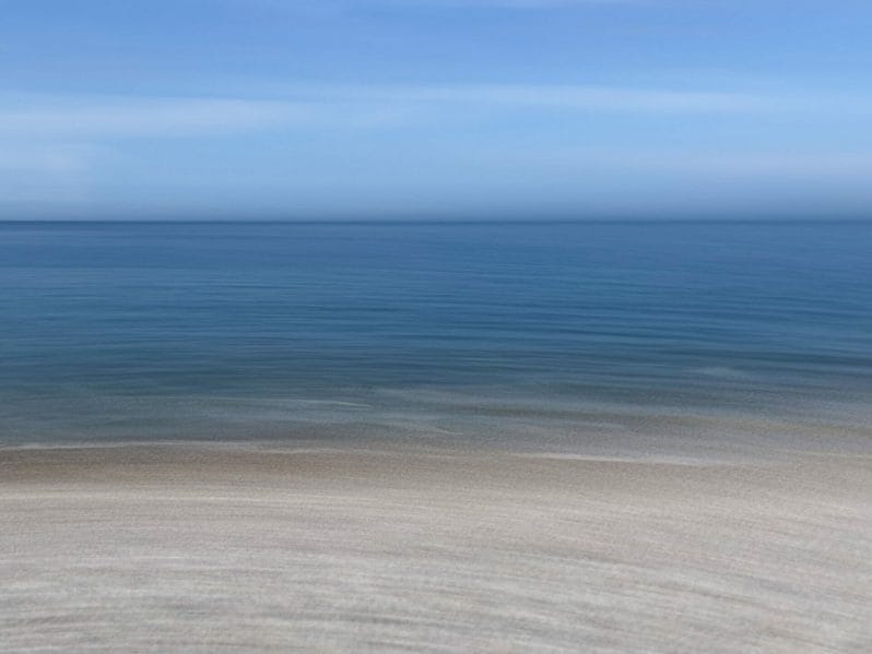A blurred image of sand, sea and sky on the Llandudno Beach in North Wales