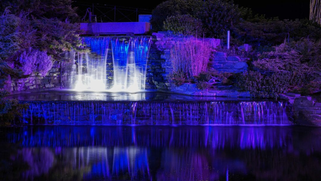 Photo of a man-made water feature in Rhyl, Norht Wales - shot at night in low-light with the coloured lights displaying. Low-Light and Long Exposure Photography - Rhyl - Roving Academy Evening