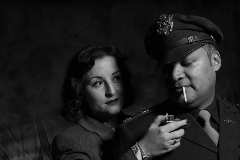 Themed Photo-Shoot:  Film Noir Photography with Welshot - Black and White Photo of Woman holding a cigarette lighter up to a man in uniform 