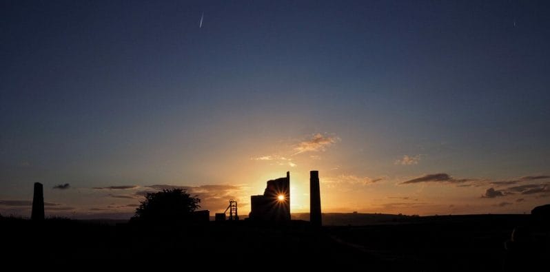 Photo of the sun setting behind Magpie Mine in the Peak District