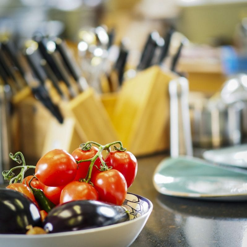 Photograph of a bowl of tomatoes and egg plant with cutlery blurred in the background - taken at a Food Styling & Photography – Anglesey Photographic Academy Evening
