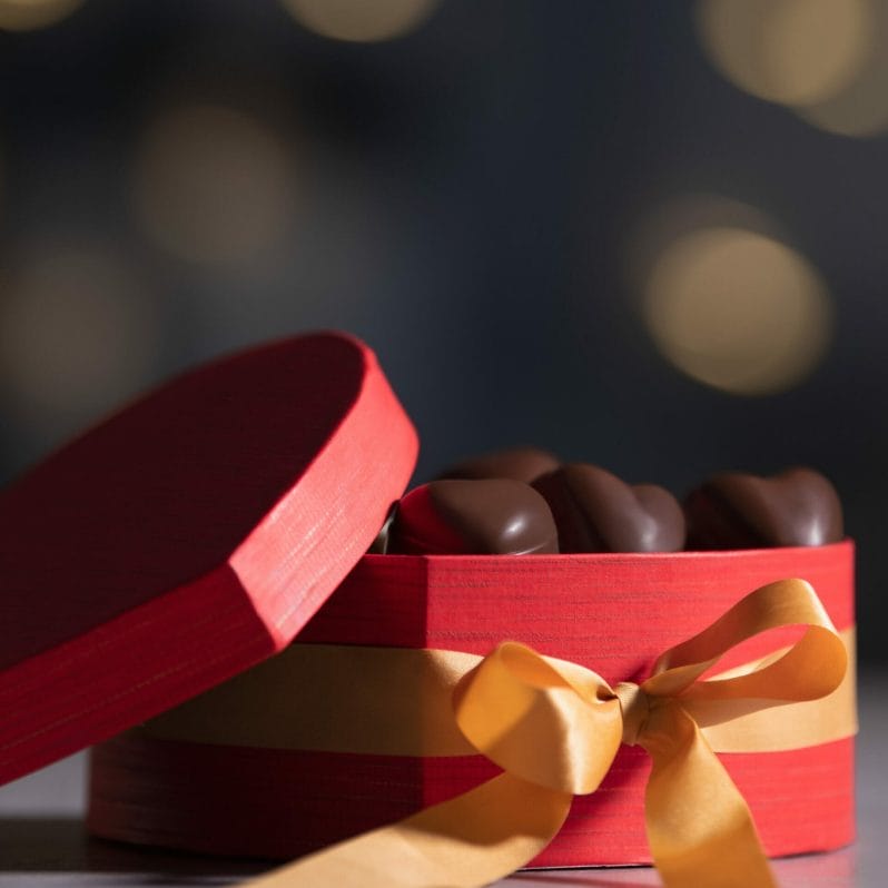 Christmas Food & Product Photography - Photo of a bed box with a yellow ribbon with chocolates
